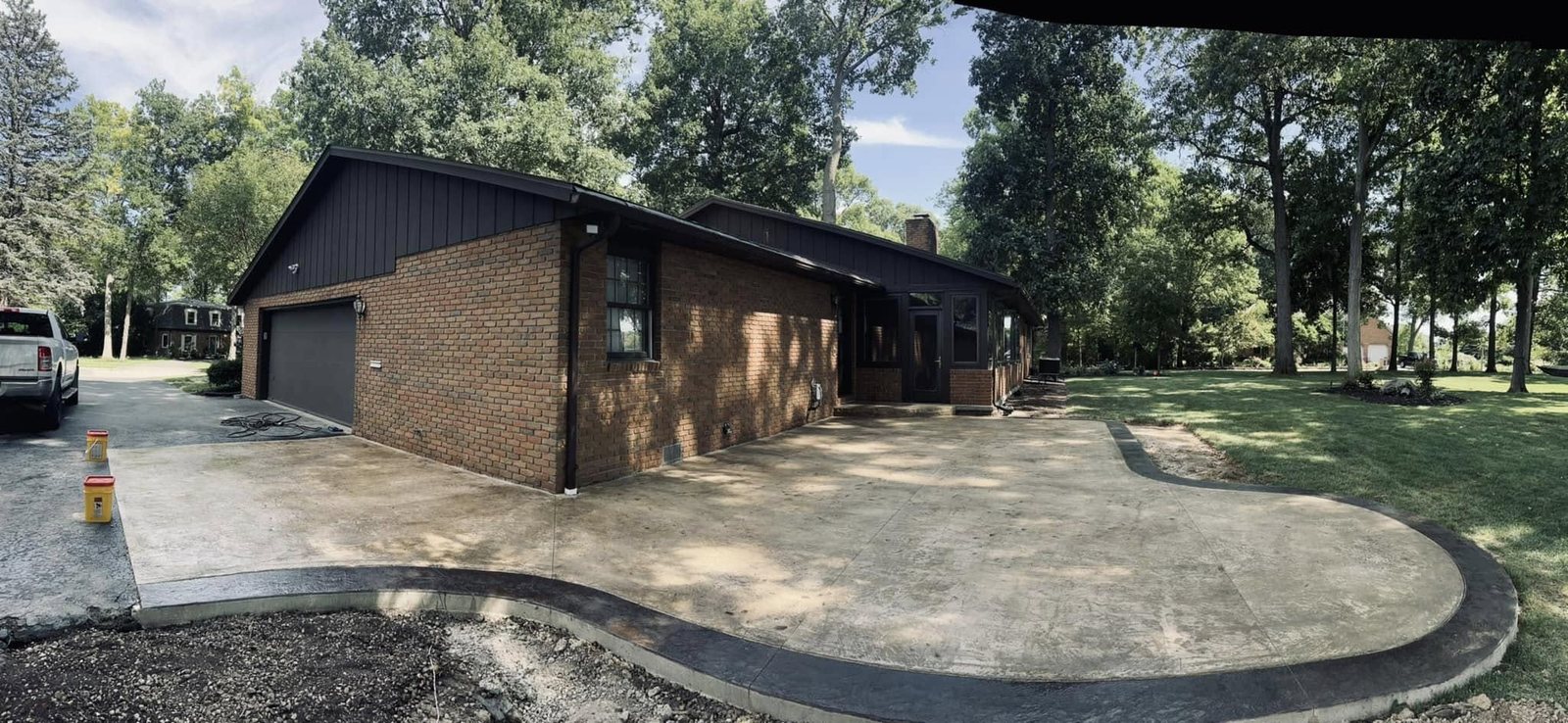 The same brick ranch home with a finished curved stamped concrete driveway